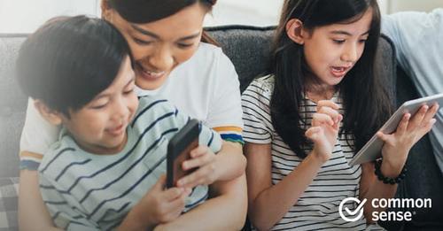 Mother with little boy and girl using phone and tablet
