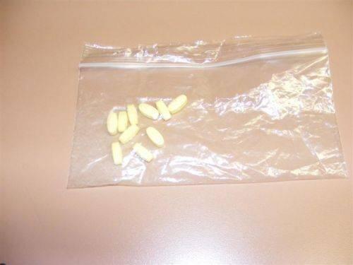 A clear bag with pills inside of it.
