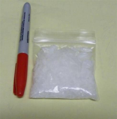 A small bag with a white substance in it next to a sharpie marker.